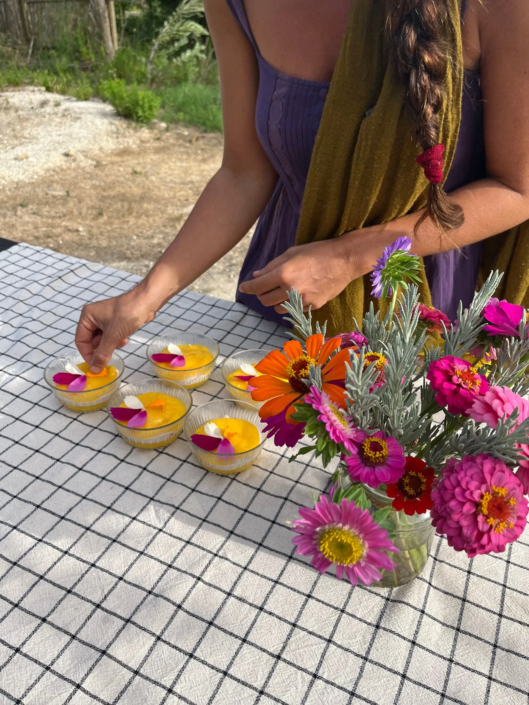 Melania decorating small desserts with flower petals